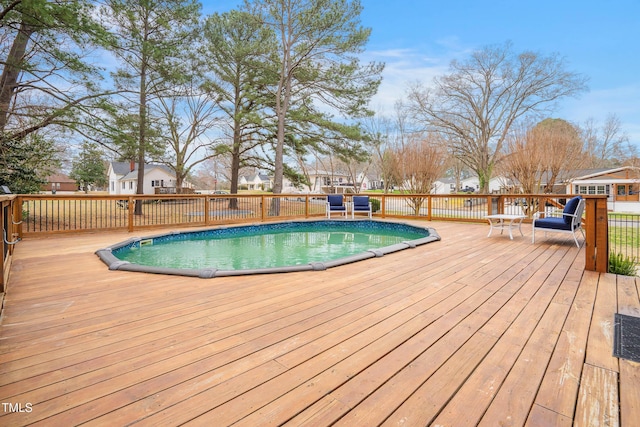 view of swimming pool with a fenced in pool and a wooden deck