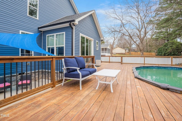 wooden deck featuring fence and an outdoor pool