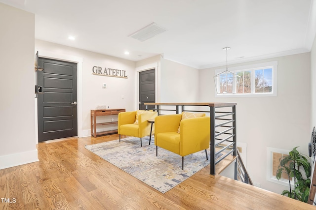 sitting room featuring baseboards, an upstairs landing, recessed lighting, wood finished floors, and a notable chandelier