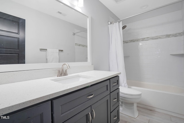 full bathroom with visible vents, toilet, shower / tub combo, wood finished floors, and vanity