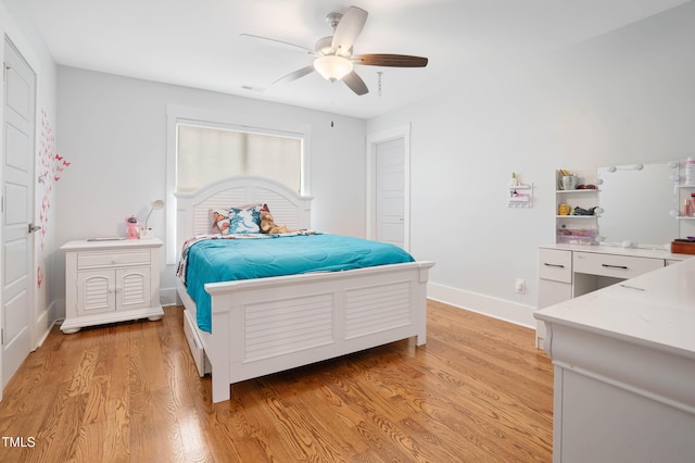 bedroom with light wood-style flooring, baseboards, and ceiling fan