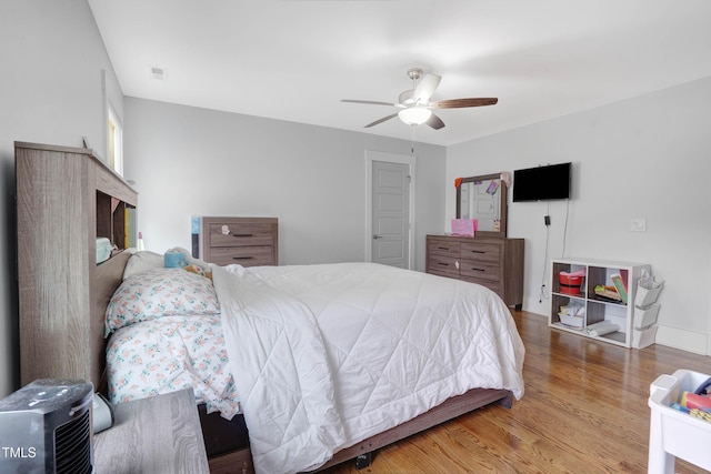 bedroom with visible vents, a ceiling fan, and wood finished floors