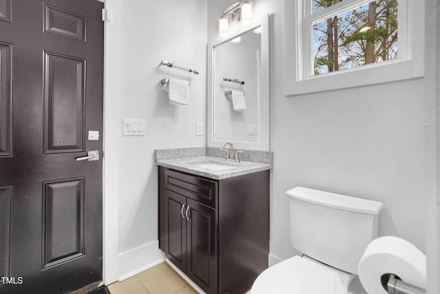 bathroom with tile patterned floors, toilet, vanity, and baseboards