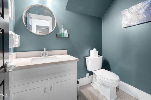 half bathroom featuring tile patterned floors, toilet, and vanity