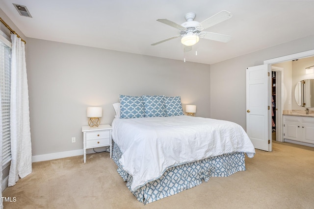 bedroom featuring visible vents, light colored carpet, connected bathroom, and baseboards