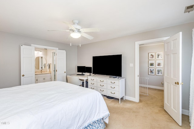 bedroom featuring visible vents, light carpet, connected bathroom, baseboards, and ceiling fan