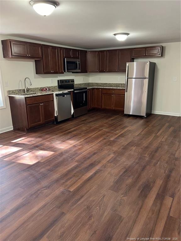 kitchen featuring dark wood-style floors, appliances with stainless steel finishes, and a sink