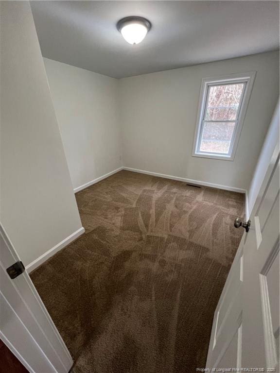 carpeted empty room with baseboards