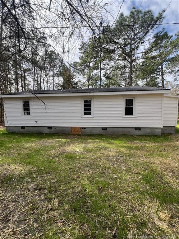 rear view of house featuring crawl space and a yard