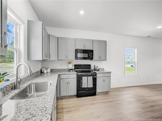 kitchen with a sink, gray cabinetry, and black appliances