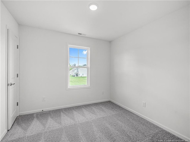 spare room with carpet flooring, baseboards, and visible vents