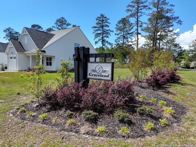 community sign with a garage and a yard