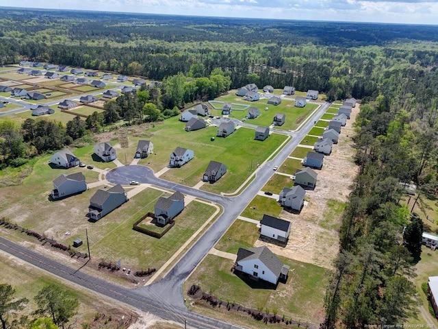 drone / aerial view with a residential view and a wooded view