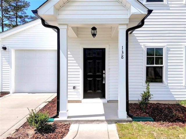 property entrance with driveway and a garage