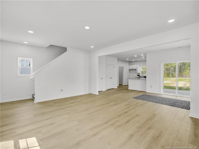 232 Penfield Way, Raeford, NC 28376 - unfurnished living room featuring light wood-type flooring, recessed lighting, stairway, and baseboards
