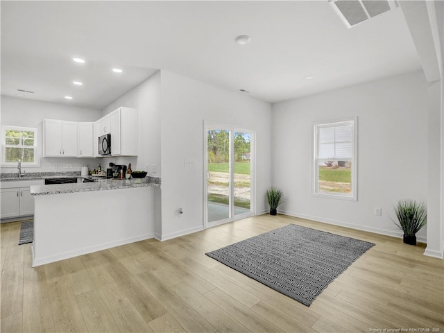 232 Penfield Way, Raeford, NC 28376 - kitchen with black microwave, light stone counters, light wood-style flooring, white cabinetry, and recessed lighting