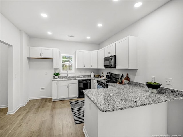 232 Penfield Way, Raeford, NC 28376 - kitchen with black appliances, a peninsula, white cabinets, a sink, and light wood-style floors