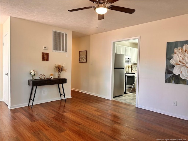 unfurnished room featuring visible vents, baseboards, and wood finished floors