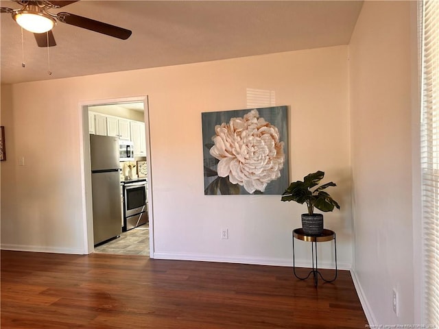 interior space featuring light wood-type flooring, baseboards, and ceiling fan