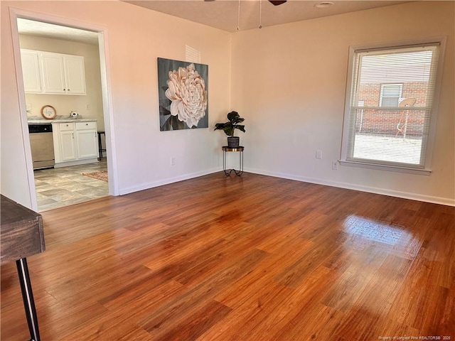 empty room with light wood-type flooring, baseboards, and ceiling fan