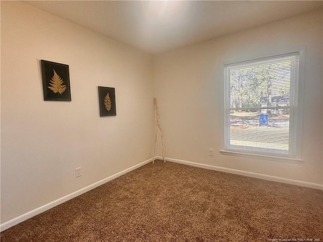 carpeted spare room with baseboards