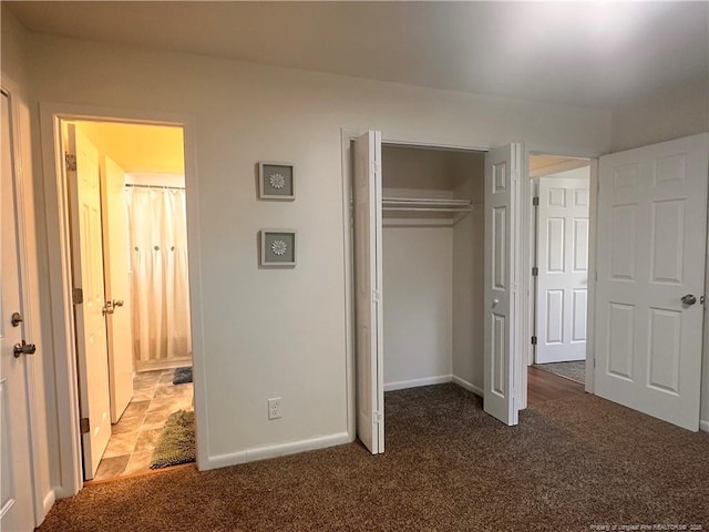 unfurnished bedroom featuring a closet, carpet flooring, and baseboards