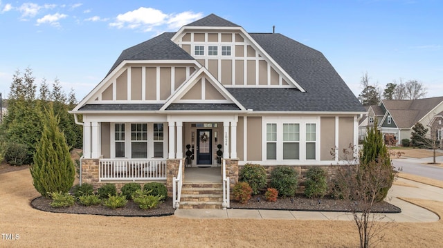 view of front of home with roof with shingles and a porch