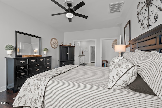 bedroom with baseboards, visible vents, dark wood finished floors, ensuite bath, and ceiling fan