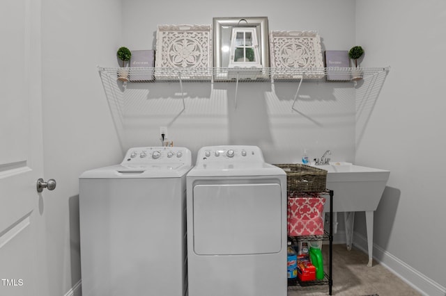 laundry area with laundry area, washing machine and dryer, and baseboards