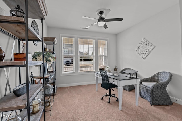 carpeted office with visible vents, baseboards, and a ceiling fan