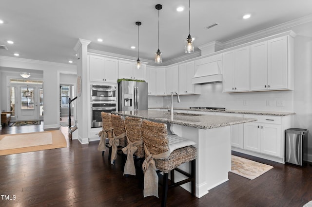 kitchen with custom range hood, dark wood-style floors, visible vents, and appliances with stainless steel finishes