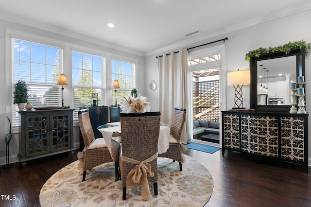 dining room with plenty of natural light, wood finished floors, visible vents, and ornamental molding