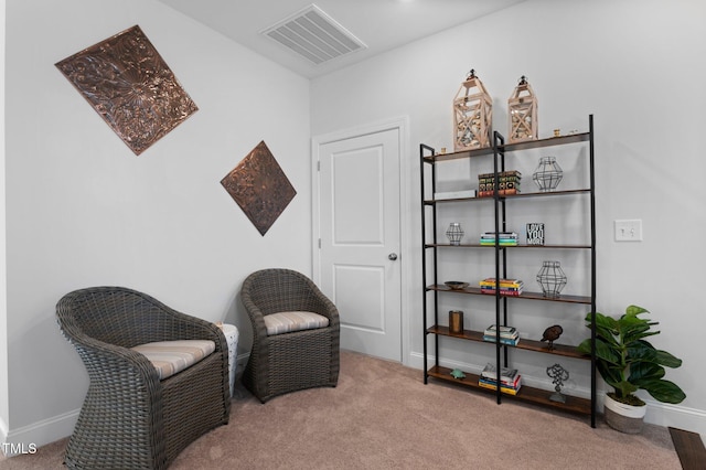 living area featuring visible vents, carpet flooring, and baseboards