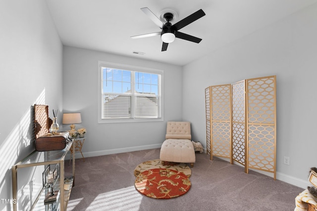 living area with visible vents, baseboards, carpet, and ceiling fan