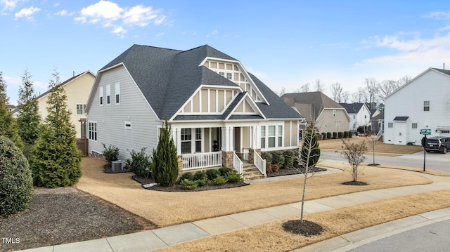 view of front facade featuring driveway, covered porch, central AC, and a shingled roof