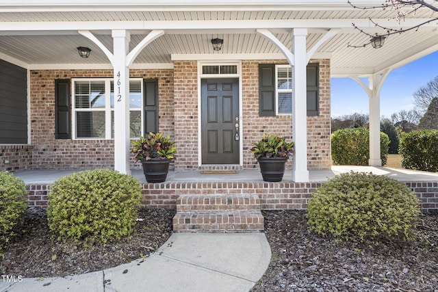 property entrance with brick siding and covered porch