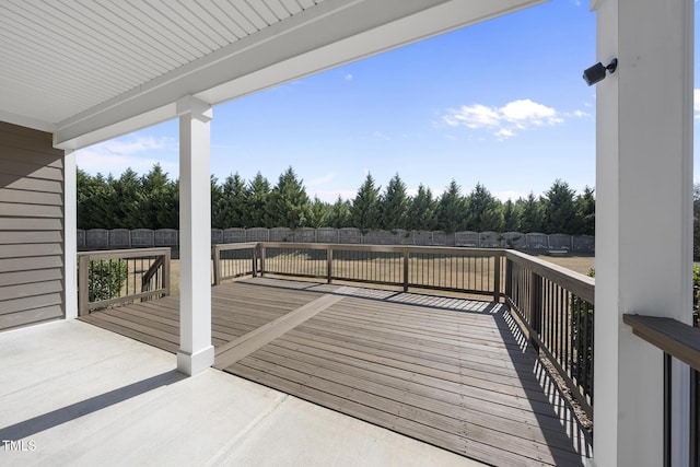 wooden terrace with a fenced backyard