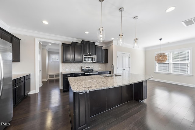 kitchen with visible vents, crown molding, decorative backsplash, stainless steel appliances, and a sink