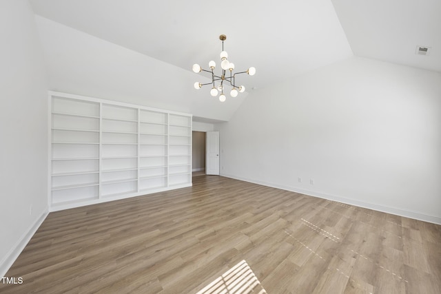 interior space featuring visible vents, baseboards, lofted ceiling, wood finished floors, and a notable chandelier