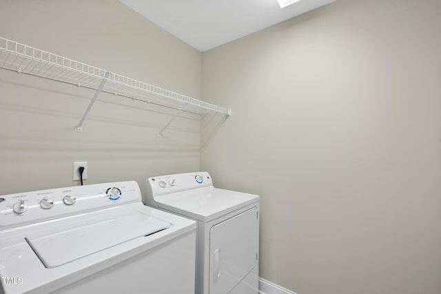 laundry room with laundry area, baseboards, and washing machine and clothes dryer