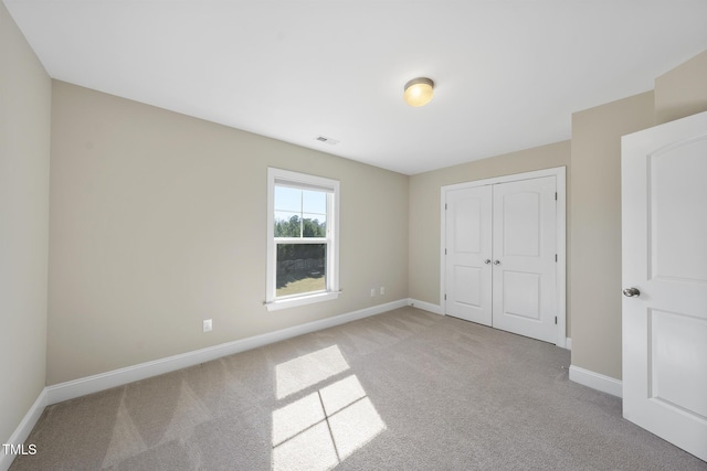 unfurnished bedroom with baseboards, visible vents, and light carpet