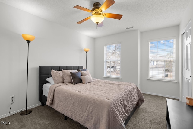 bedroom featuring visible vents, a ceiling fan, a textured ceiling, carpet floors, and baseboards