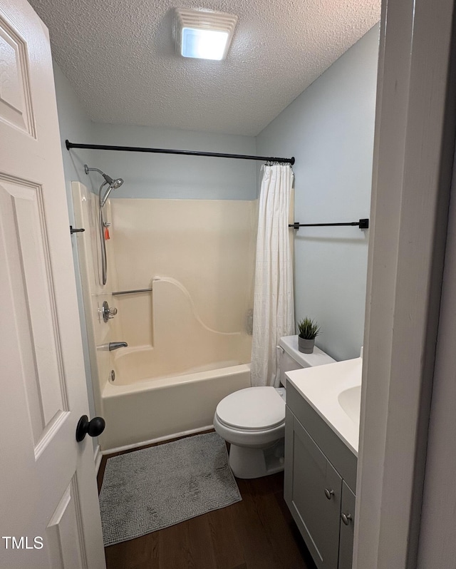 full bathroom with toilet, shower / bath combo, a textured ceiling, wood finished floors, and vanity