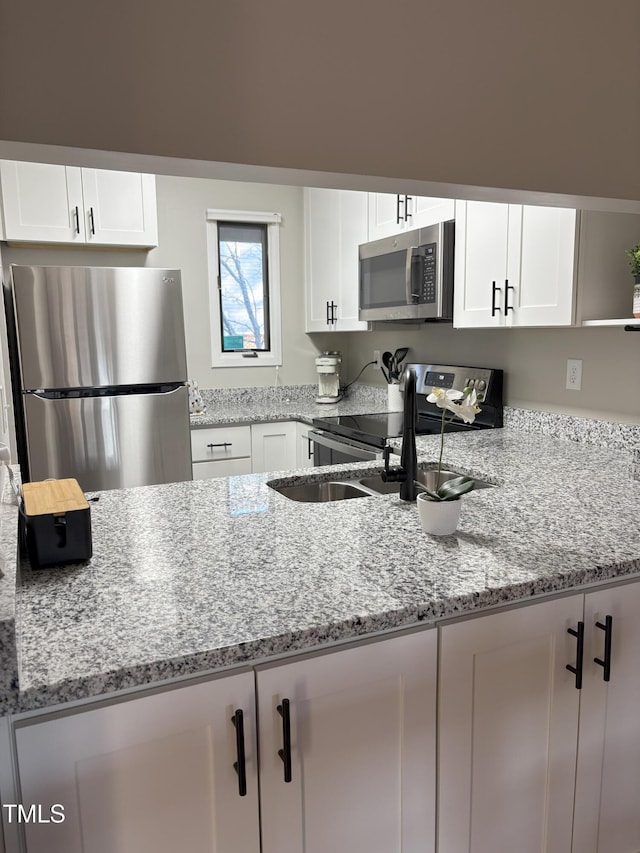 kitchen featuring white cabinetry, light stone countertops, and appliances with stainless steel finishes