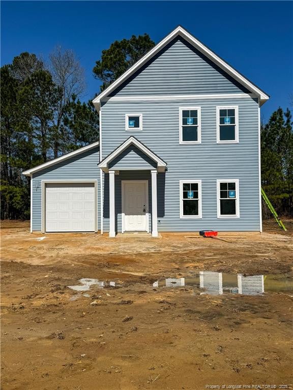 view of front of house featuring an attached garage and dirt driveway