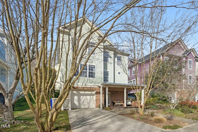 view of front of home featuring brick siding, covered porch, driveway, and an attached garage