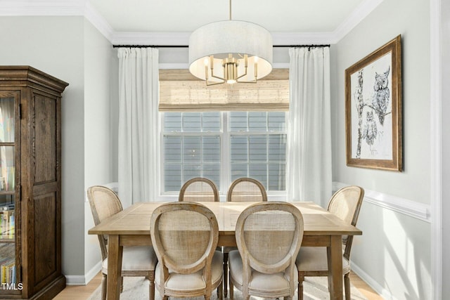 dining space featuring light wood-type flooring, baseboards, an inviting chandelier, and crown molding