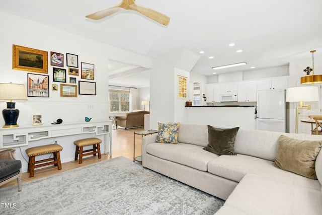 living room with recessed lighting, light wood-type flooring, and a ceiling fan