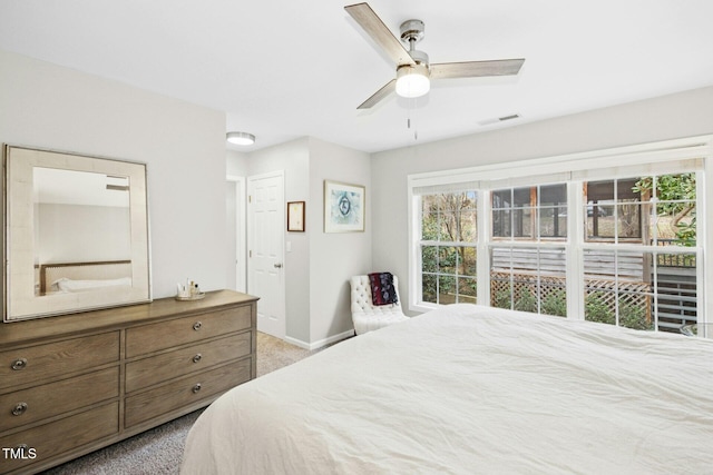 carpeted bedroom with visible vents, a ceiling fan, and baseboards