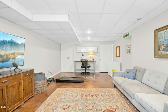 living room with baseboards, a drop ceiling, and finished concrete floors